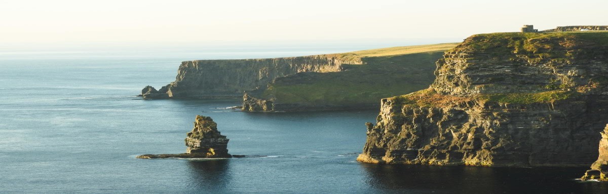 The iconic Cliffs of Moher, sea cliffs in Western Ireland over the Atlantic Ocean on a clear day.