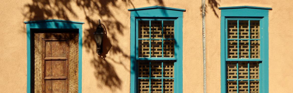 Pueblo building with turquoise border on windows and doors in Santa Fe.