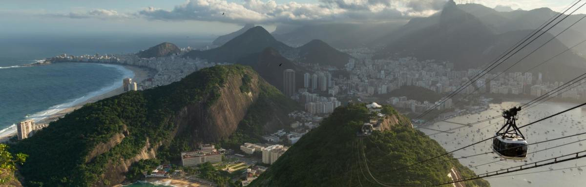 City of Rio de Janeiro beside lush green mountains and ocean. 